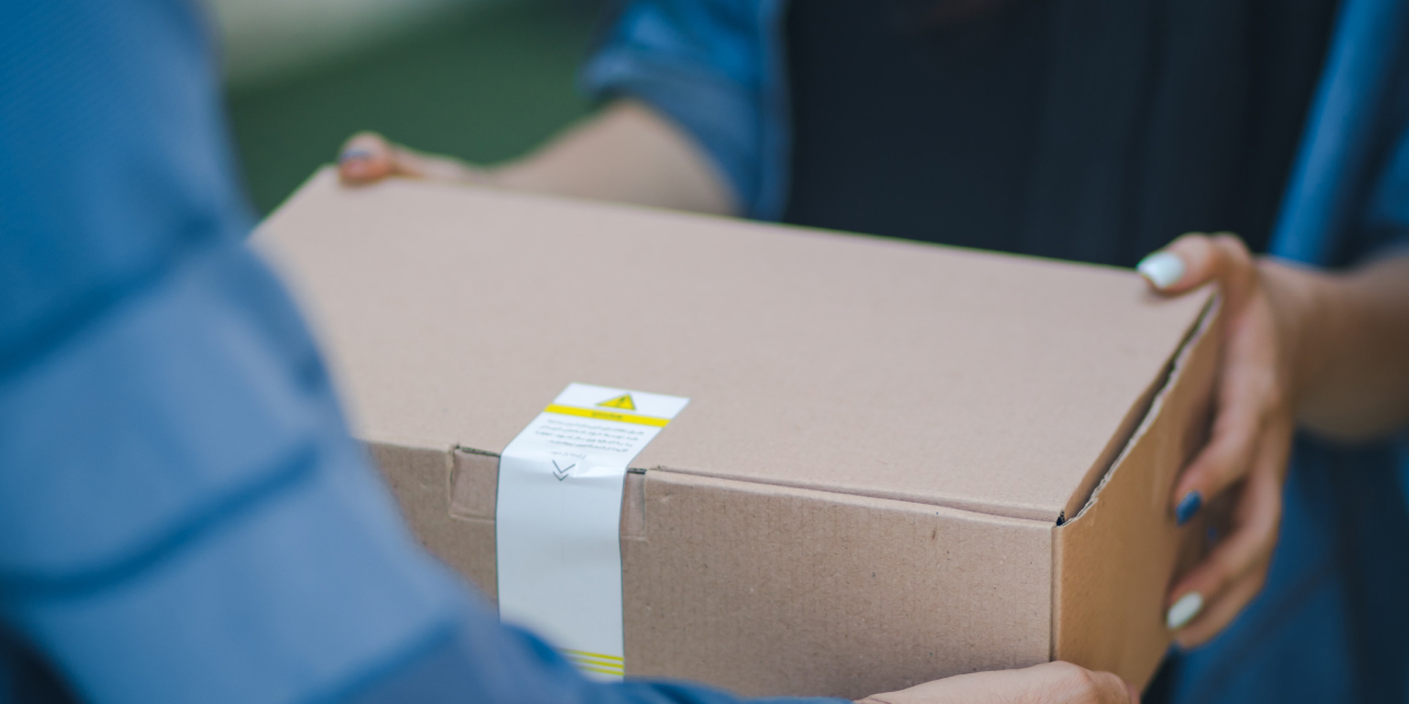 Delivery man hands a package to a woman